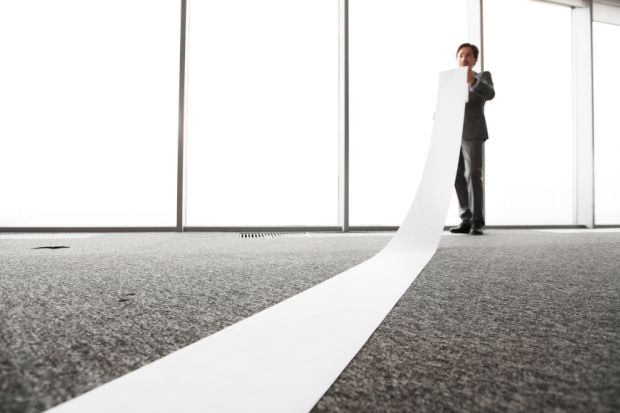 Office worker unrolling long sheet