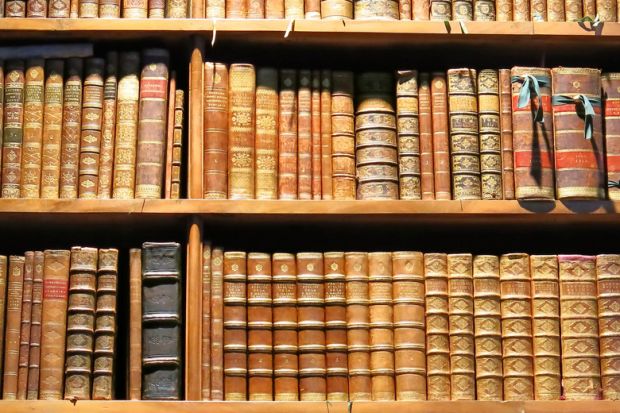 Old books arranged on library bookshelves