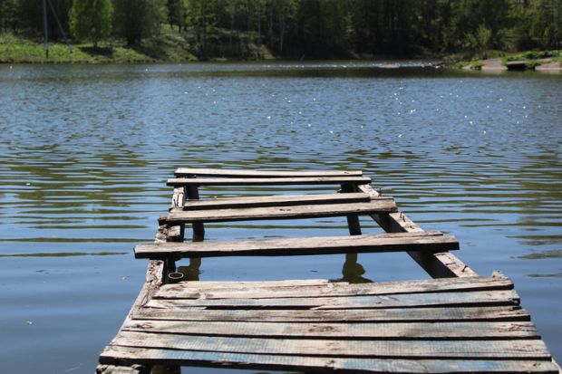 Old wooden bridge pier on the lake