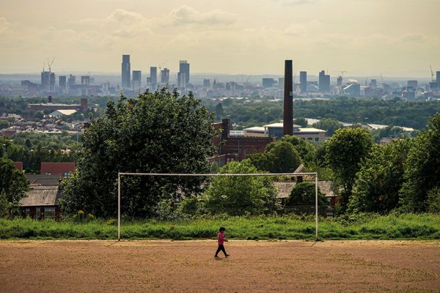 A general view of an old cotton mill in Oldham with the city of Manchester on the horizon, 2020