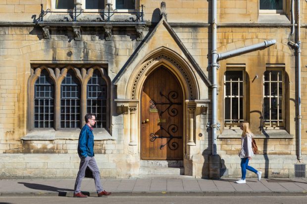 OXFORD, ENGLAND - 8 APRIL 2017 - People walk on a street in Oxford university on a fine spring day of April 8, 2017 in Oxford, England.