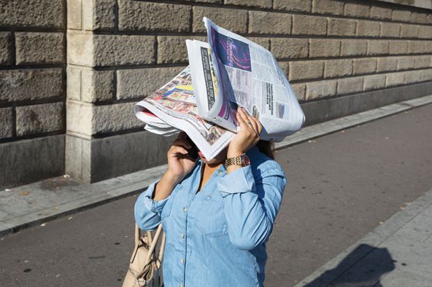 Woman on mobile phone with head covered by newspaper, illustrating review of Forgotten Wives: How Women Get Written Out of History By Ann Oakley
