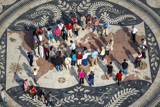 Tourists examining map of the world and compass rose on pavement behind Monument to the Discoveries, Lisbon, Portugal. To illustrate the Academy of Management (AOM) holding conferences outside the US. Tourists examining map of the world and compass rose on pavement behind Monument to the Discoveries, Lisbon, Portugal. To illustrate the Academy of Management (AOM) holding conferences outside the US.