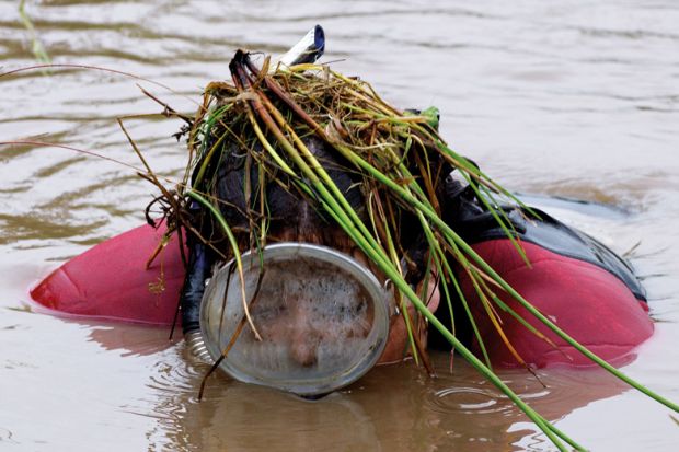 Person in scuba gear emerging from bog