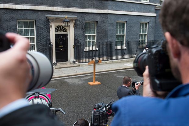 Photographers waiting for an announcement with empty lectern outside Downing Street. To illustrate that universities waiting for government intervention are likely to be disappointed.