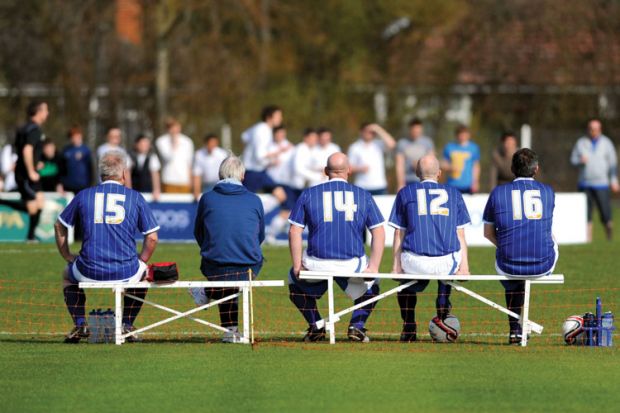 Players sitting on bench at football game
