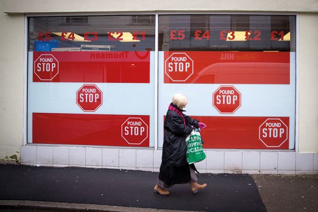 A woman passes a shop front in Merthyr Tydfil, Wales, in 2016