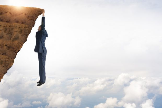 A man hangs from a precipice