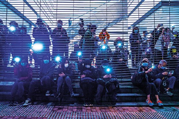 Pro-democracy demonstrators raise flashlights outside West Kowloon Magistrates’ Courts during a hearing for 47 opposition activists charged with violating the city’s national security law in Hong Kong, China, on March 4, 2021.