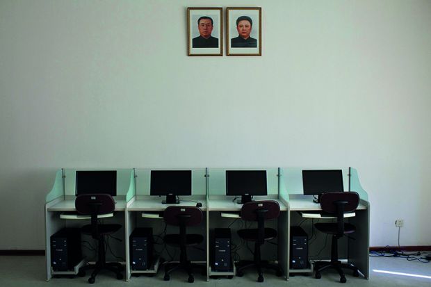 North Korea’s late leaders Kim Il Sung and Kim Jong Il hang on a wall over a bank of computers at Pyongyang University of Science and Technology