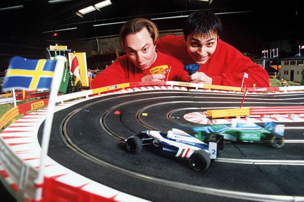 Two men beside a toy race track