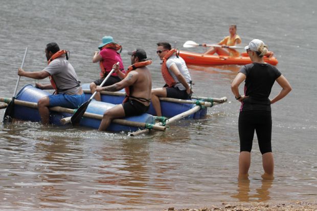 People paddling on a makeshift raft People paddling on a makeshift raft