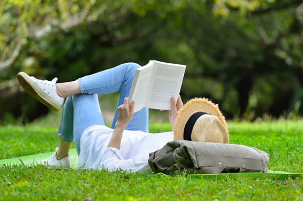 A woman lying on her back reading A woman lying on her back reading