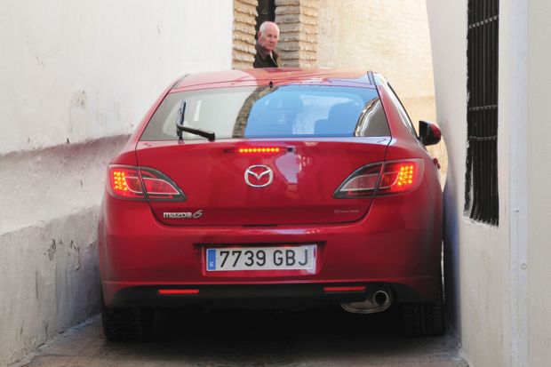 Red car stuck in alleyway, Córdoba, Spain