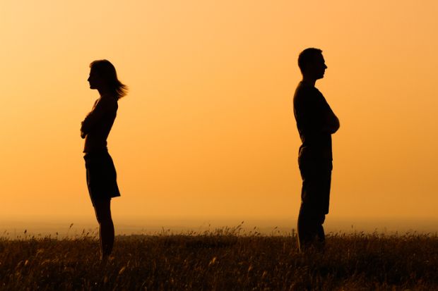 Two people in silhouette looking away from each other