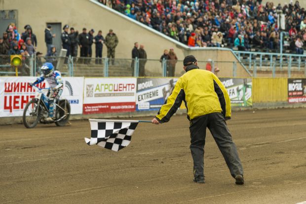 Rivne, Ukraine - 11 October 2015 Man with a checkered flag finish shows at the Open Cup Speedway to the day of the city Rivne