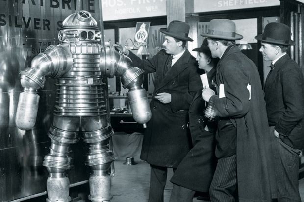 Men examining 1950s-style robot
