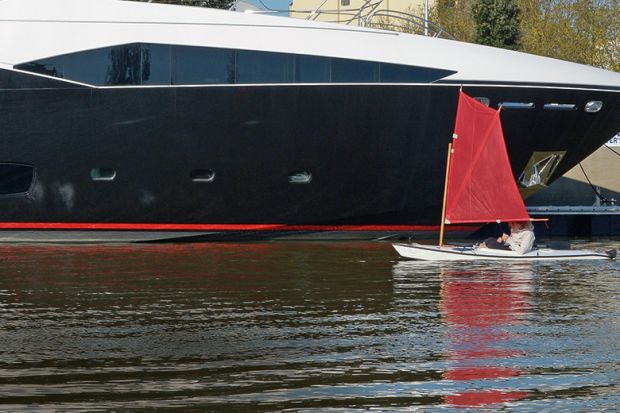 Tiny boat next to luxury yacht