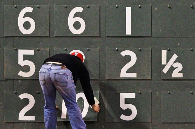 A scoreboard worker changes the scores, to illustrate a new online tool that seeks to correct biases in student evaluations.