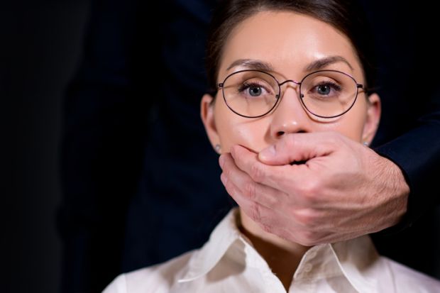 A man puts his hand over a woman's mouth A man puts his hand over a woman's mouth