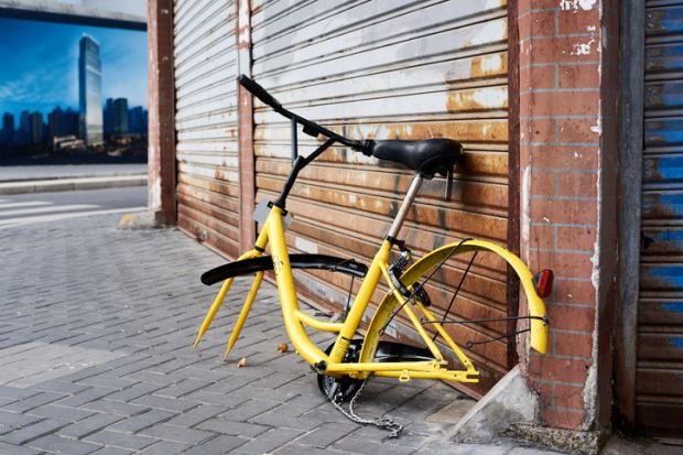 Shanghai, China - April 08, 2017 Discarded and vandalized bicycle of popular bikesharing company ofo laying in the street