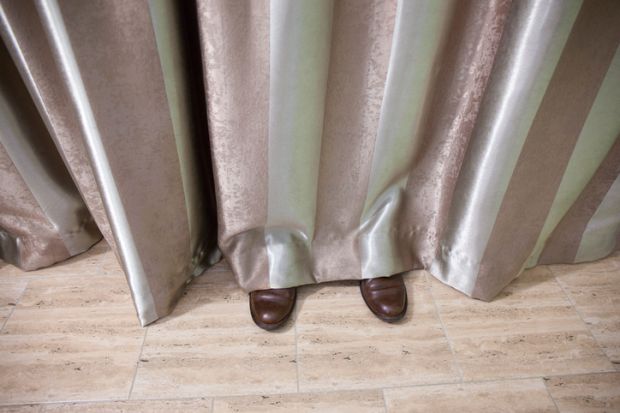 Shoes visible beneath curtain