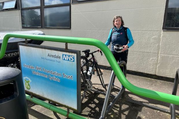 Shunna Burke after cycling to hospital Shunna Burke after cycling to hospital , stood by NHS sign