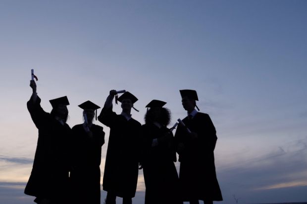 Silhouette of graduates with certificates on a sunset background