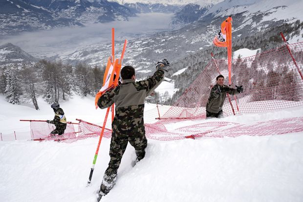 Swiss soldats remove gates at the FIS Alpine Skiing World Cup in Crans-Montana, 2016, illustrating new code of academic conduct