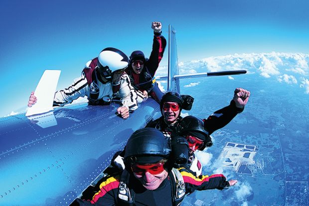 A group of skydivers clinging to a plane