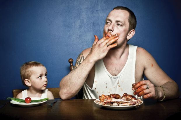 Small child and man eating at table