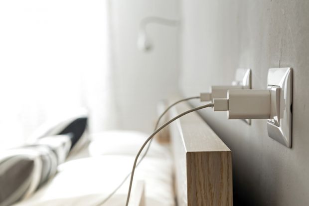 Smartphone chargers plugged into home electrical outlets