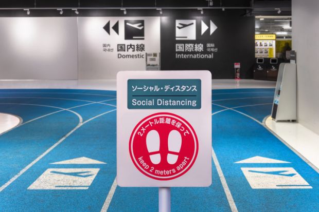 Social-distancing sign with footprints icon at Tokyo airport