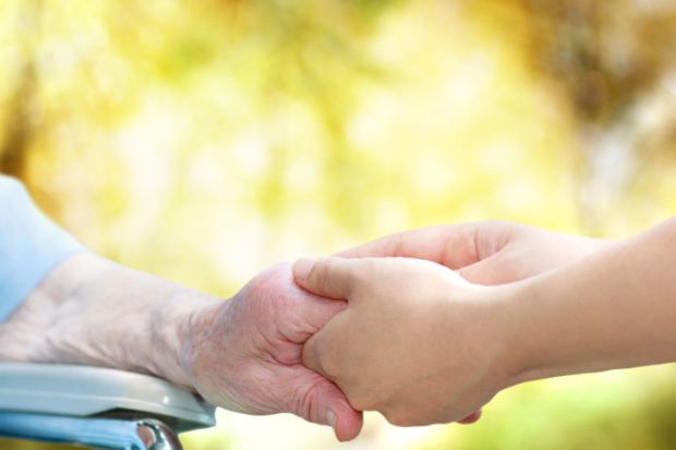 Old woman olding carer's hand