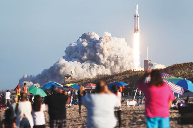 People watch SpaceX Falcon Heavy rocket lift off from Kennedy Space Center on April 11, 2019 in Titusville, Florida