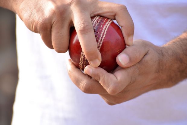 A spin bowler’s hands, holding the ball