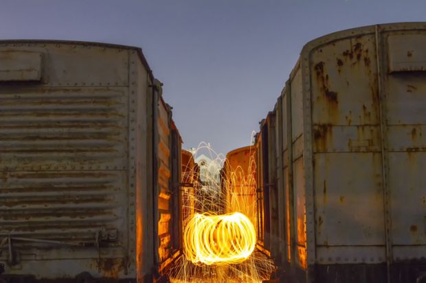 A spinning steel wool firework between 2 train carriages, symbolising spinouts