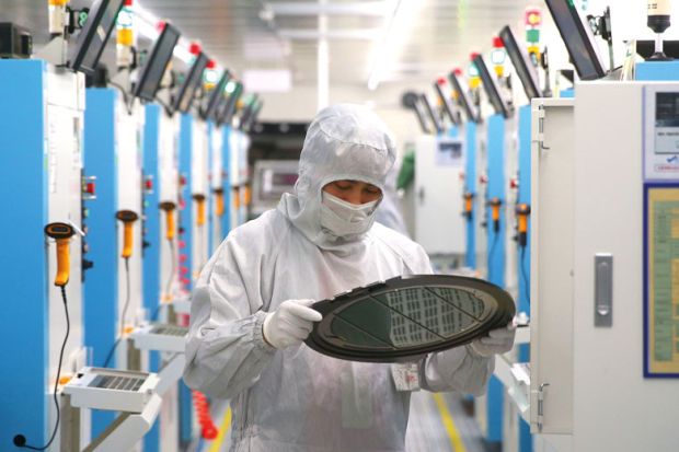 Employees work on the production line of silicon wafer at a factory of GalaxyCore Inc. to illustrate ndustry-focused universities tackle Chinese skills gaps