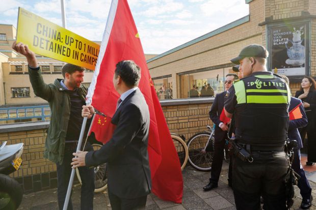 Supporters of Chinese Prime Minister Li Keqiang attempt to block an activist of Amnesty International holding a protest with a Chinese flag to illustrate VU Amsterdam row ‘shows need for clear policies’ on China ties
