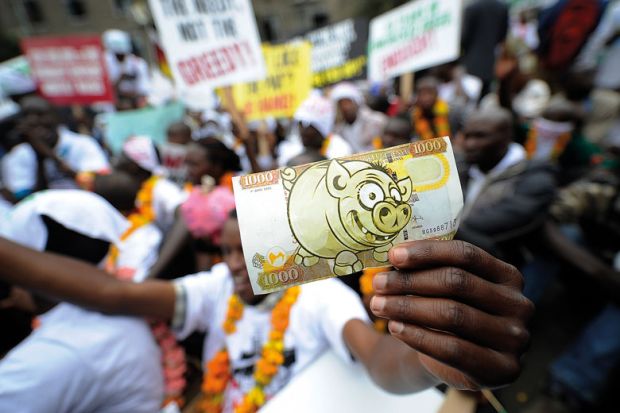 Protesters hold a fake bill imitation of local currency during a demonstration to illustrate Visa money-lending scams ‘commonplace’, warns ex-minister