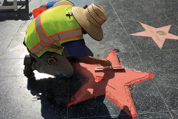 A worker repairs a star on the Hollywood Walk of Fame A worker repairs a star on the Hollywood Walk of Fame