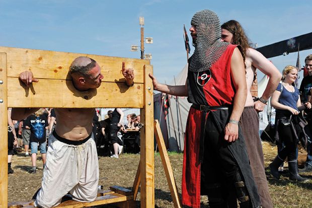 A man in stocks at a modern-day fete