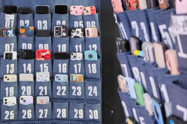 Storage of mobile phones in numbered pouches. To illustrate device-free classrooms. Storage of mobile phones in numbered pouches. To illustrate device-free classrooms.