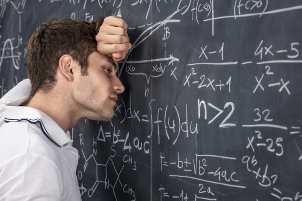 A stressed lecturer leans against a blackboard