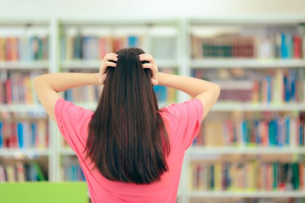 Stressed Student Preparing for Exams in School Library