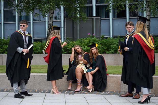 Students relax on campus at the University of Bolton after receiving their degree certificates. Some of them look uncertain. To illustrate that a “challenging” graduate labour market in the UK could erode trust in the higher education sector.