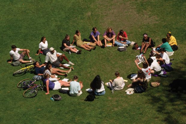 Students sitting in circle outside on lawn