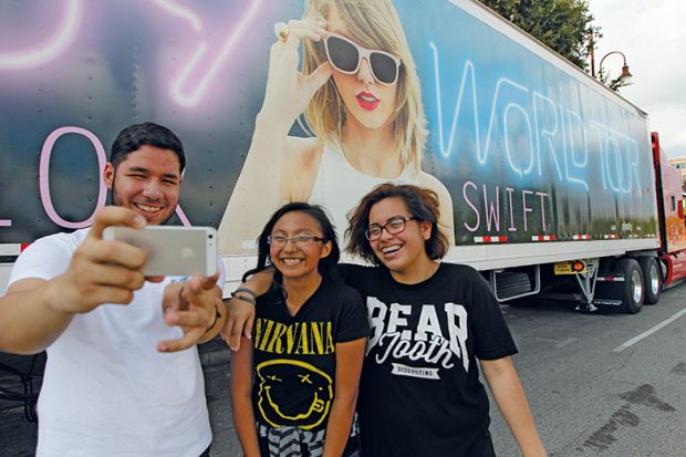 Taylor Swift fans in front of one of the many semi-trucks in Houston to illustrate For Taylor Swift, lecturers find a place in this world