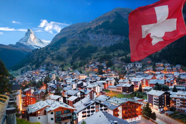 Swiss town with flag of Switzerland and Swiss Alps (Matterhorn) in background
