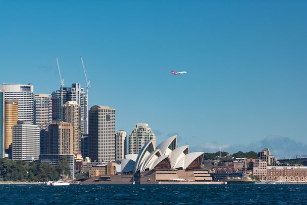 A plane flies over Sydney Opera House